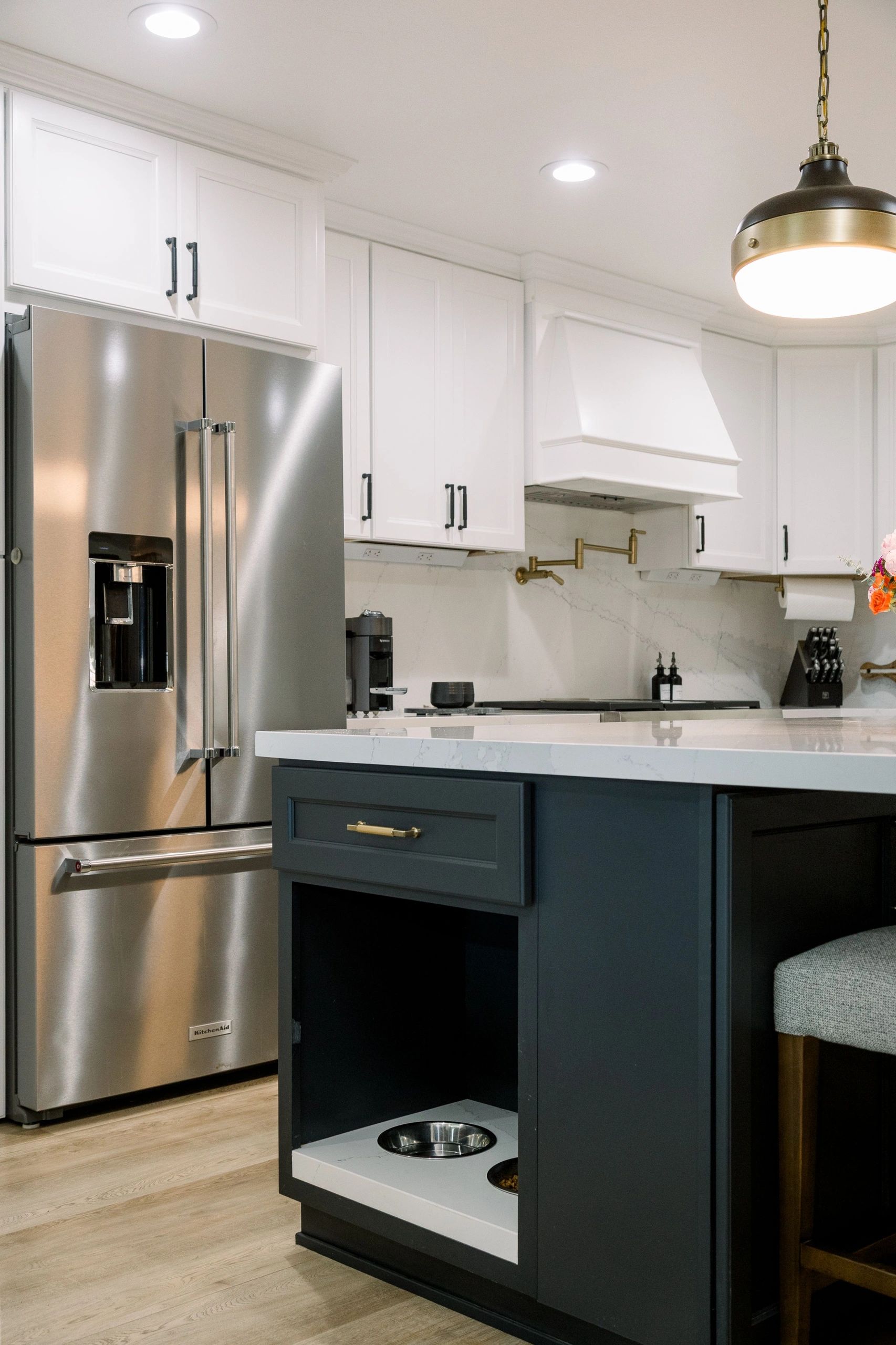Kitchen with stainless steel fridge the the left and partial view of the island.