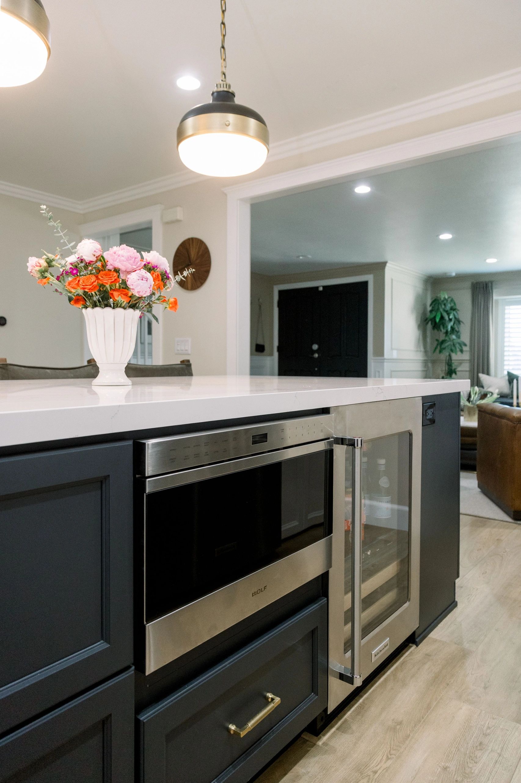 Close up of oven and mini fridge implimented in island counter top with dark blue accents. 