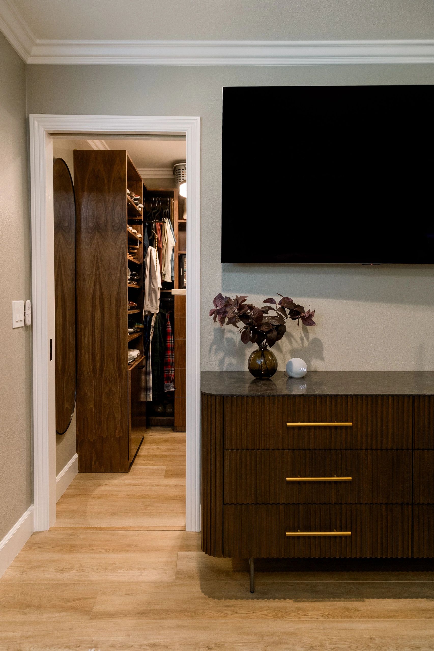 Partial view of closet entryway and dresser, both featuring wooden cabinetry.