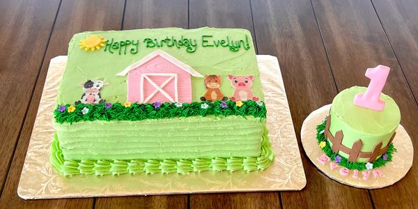 Farm-themed birthday cakes with animals and a pink barn for Evelyn's first birthday.