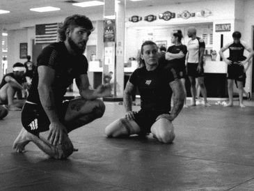 Two men in a martial arts training session indoors.