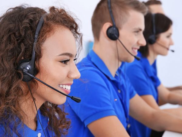 Printing experts giving advice on phone for customers needing help with printing or graphic design.