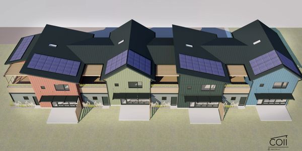 Row of modern townhouses with solar panels on roofs.