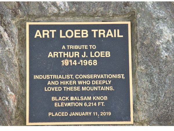 A picture of The Art Loeb Trail tribute plaque that is dedicated to Arthur J, Loeb. 