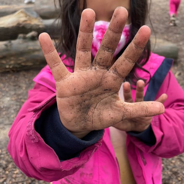 Student at recess showing hands with dirt on them