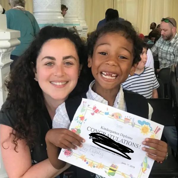 Teacher Liz Rosenberg smiling with her student at the end of the school year holding an award