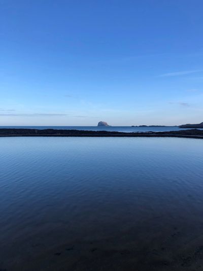 Image of North Berwick showing a calm sea and blue sky
