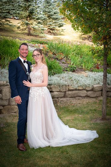 Bride and groom posing outdoors on their wedding day.
