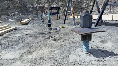 Close-up of foundation bolts and construction site preparation.