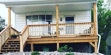 Limestone rock retaining garden with river stone accent in front of house with wooden porch