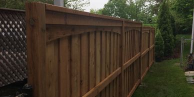 New wooden fence with metal gate at side of building