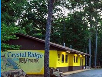 Yellow building with lights on, trees and large boulders
