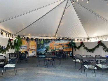 Empty outdoor seating area under a decorated tent.