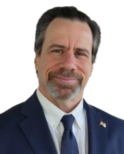 A middle-aged man in a navy suit and tie smiling.