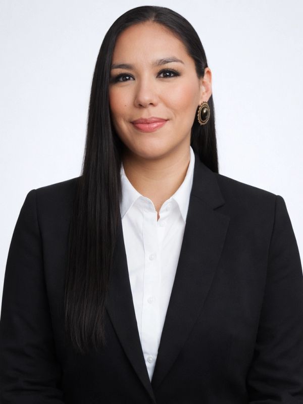 Professional woman in a black blazer and white shirt with long straight hair.