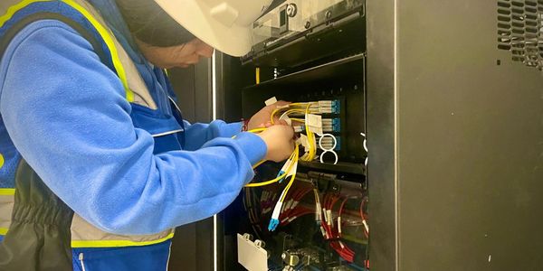 TexTech technician patching single mode fiber to IDF cabinet at Amazon flex facility in Jackson, MS.