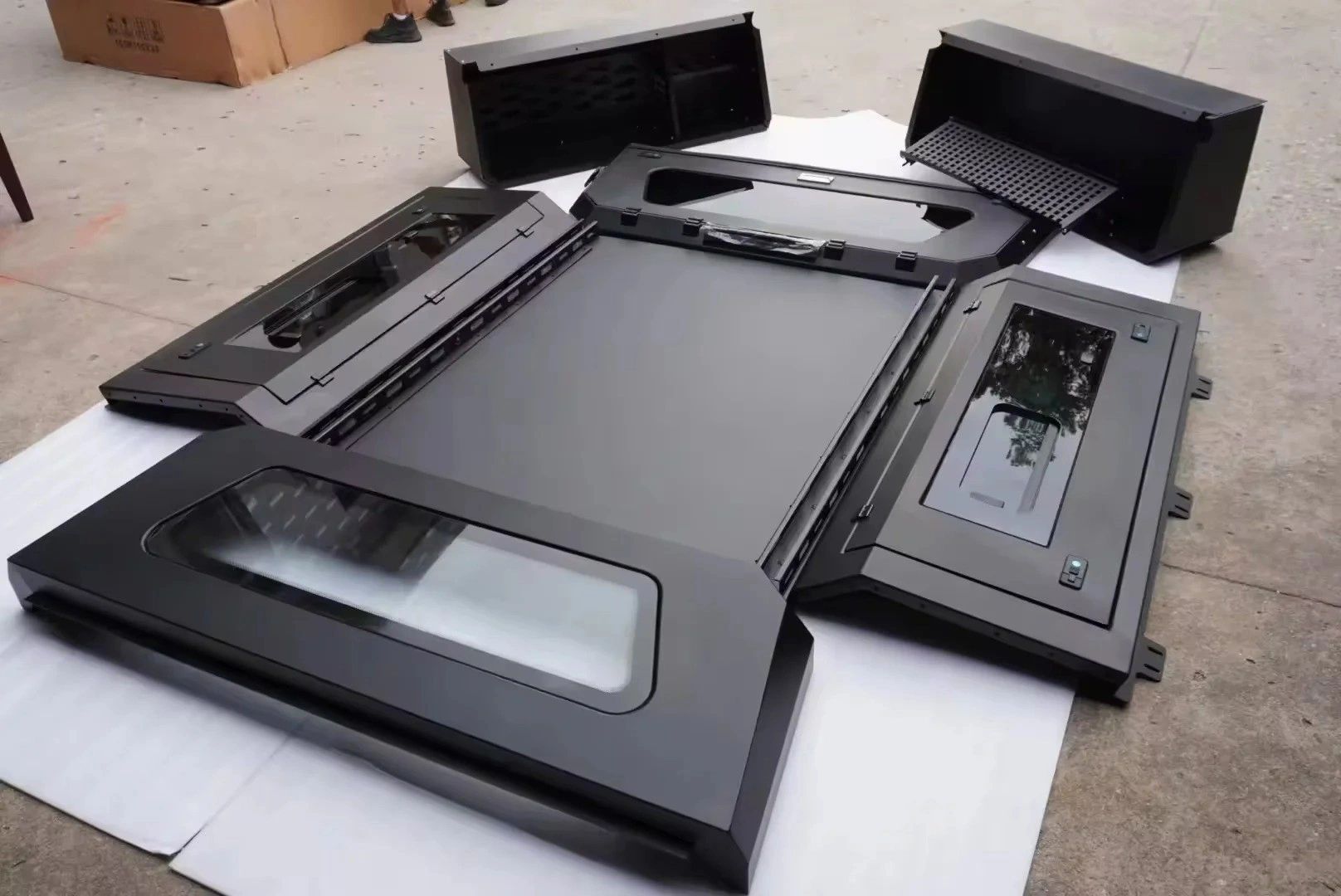 Disassembled black computer case panels with transparent windows.