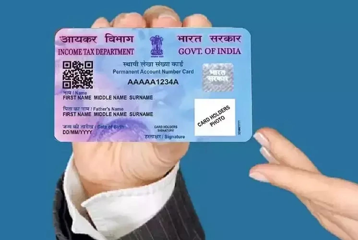 Person holding an Indian PAN card against a blue background.