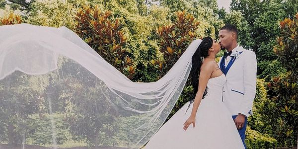Bride and groom share a kiss outdoors.