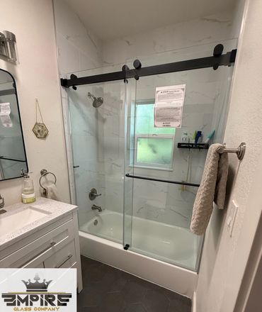 Modern bathroom with glass shower doors and hexagonal floor tiles.
