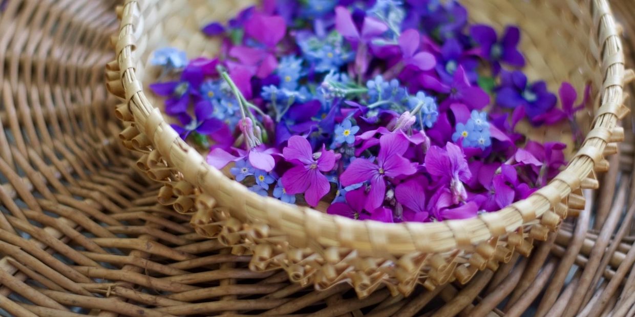 purple and blue flowers in a woven basket.