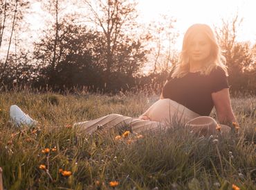 Schwanger Wiese Blumenwiese Babybauch Shooting Schwangerschaft Sonne Sundown Alina Schwertner