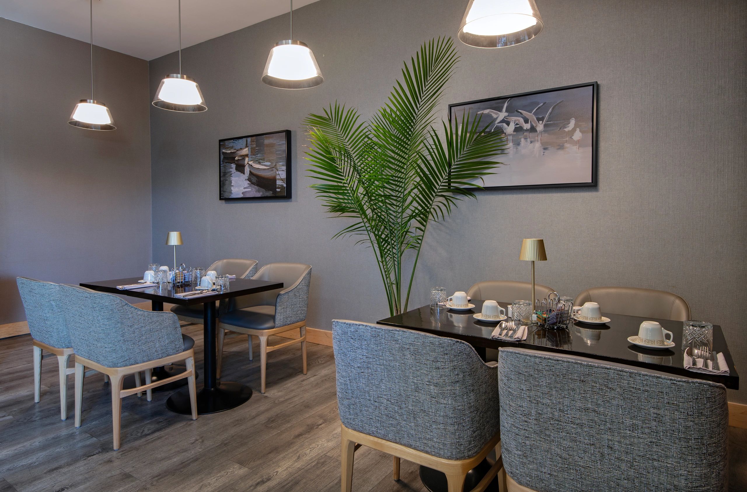 Modern dining room with cozy chairs and pendant lights.