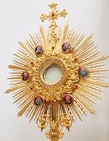 Ornate golden religious monstrance with a cross.