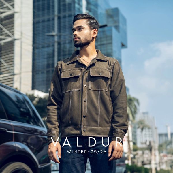 Man wearing a stylish brown jacket in an urban setting.
