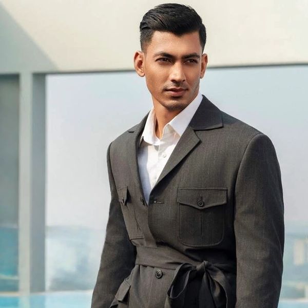 Man in a stylish dark suit with a white shirt.