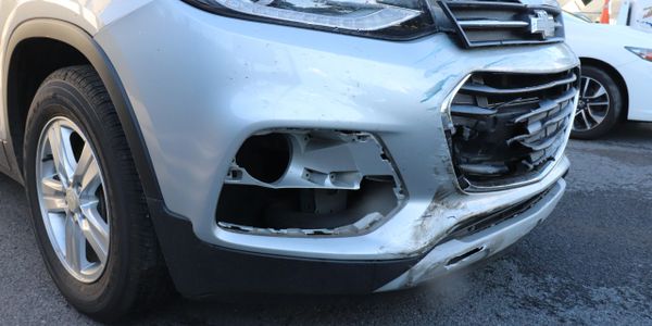devant de voiture grise avec pare-choc et calandres endommagés suite à une collision automobile