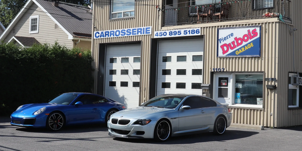  porsche 911  et bmw M6 devant l'immeuble abritant le commerce Carrosserie Pierre Dubois