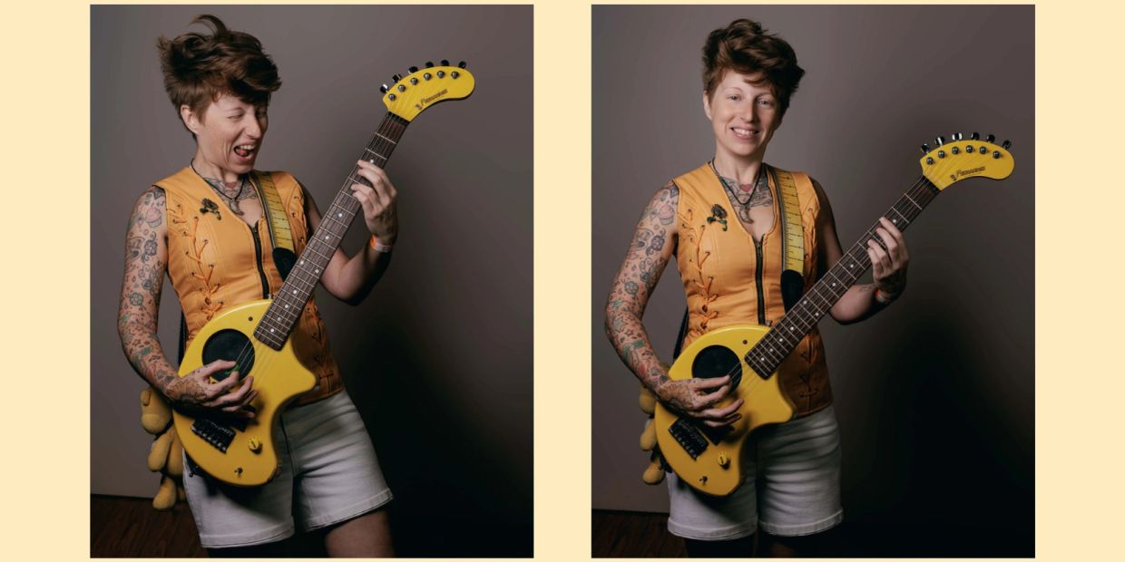 Person with tattoos playing a yellow electric guitar, smiling and making a playful face.