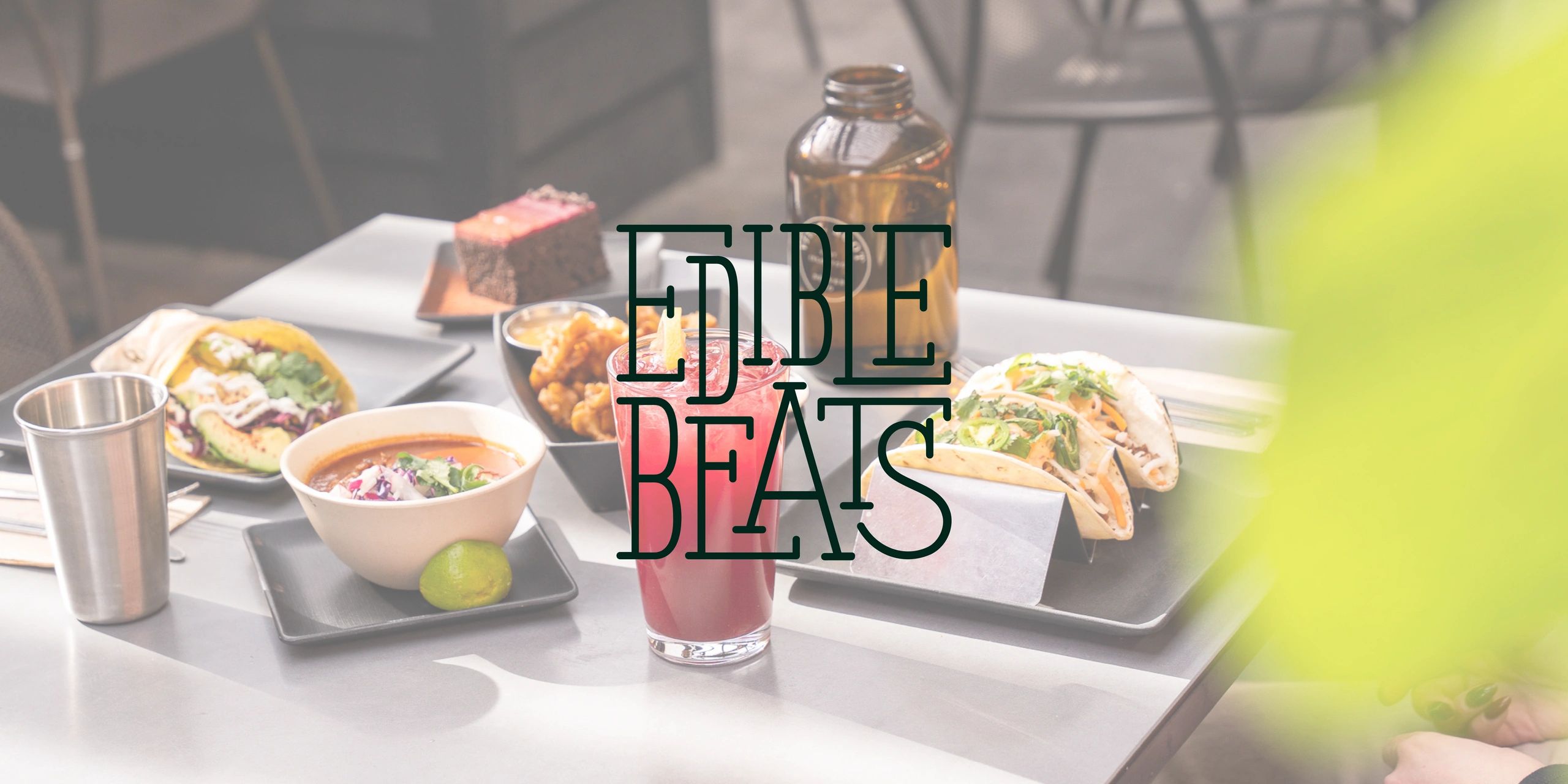 A tasty spread of tacos, soup, and a refreshing drink on a cafe table.