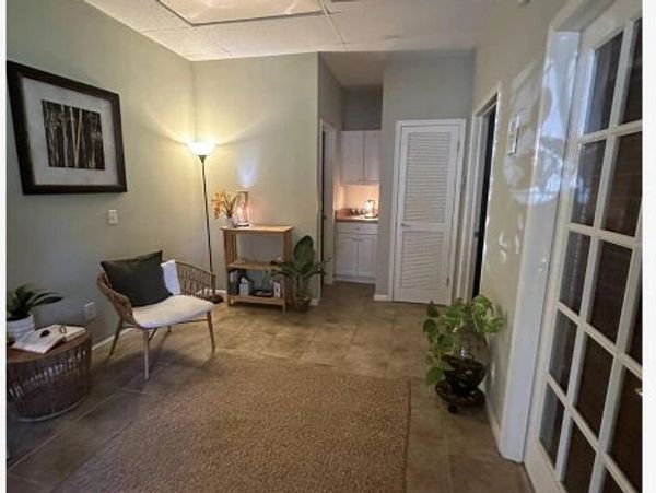 Cozy room with wicker chair, plants, and soft lighting.