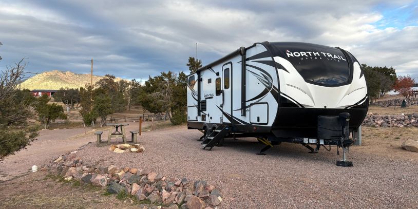 Modern North Trail camper parked in scenic campground.