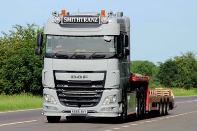 A silver DAF truck labeled SMITHTRANZ driving on a road.