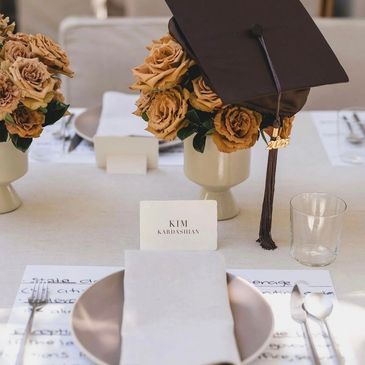 Elegant graduation table setting with a cap and roses for Kim Kardashian.