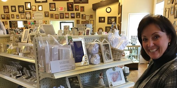 Anne setting up a display of religious gifts, including First Communion Veils.