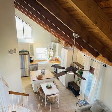 Cozy attic kitchen and dining area with wooden roof beams and modern appliances.