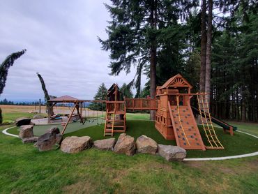 The backyard dream!  Low Maintenace Putting green with play structure area. 