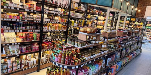 A well-stocked grocery store aisle with various jars, bottles, and packaged goods.
