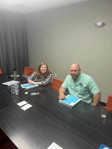 Two people sitting on Chair in front of a desk