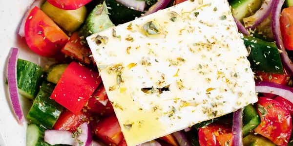 A fresh Greek salad with tomatoes, cucumbers, onions, and feta cheese.