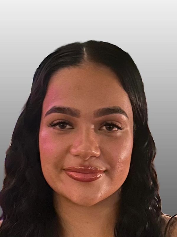 Portrait of a woman with curly black hair and glossy lips.