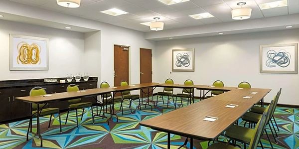 Modern conference room with U-shaped tables and colorful geometric carpet.