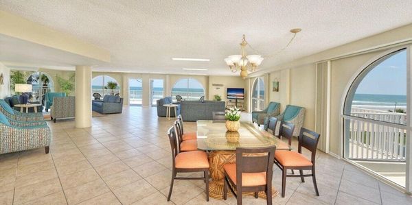 Spacious beachside living room with dining area and ocean view windows.