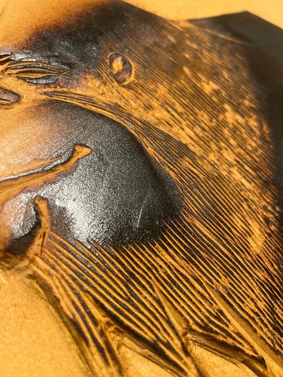 Close-up of textured wood carving with dark and light patterns.