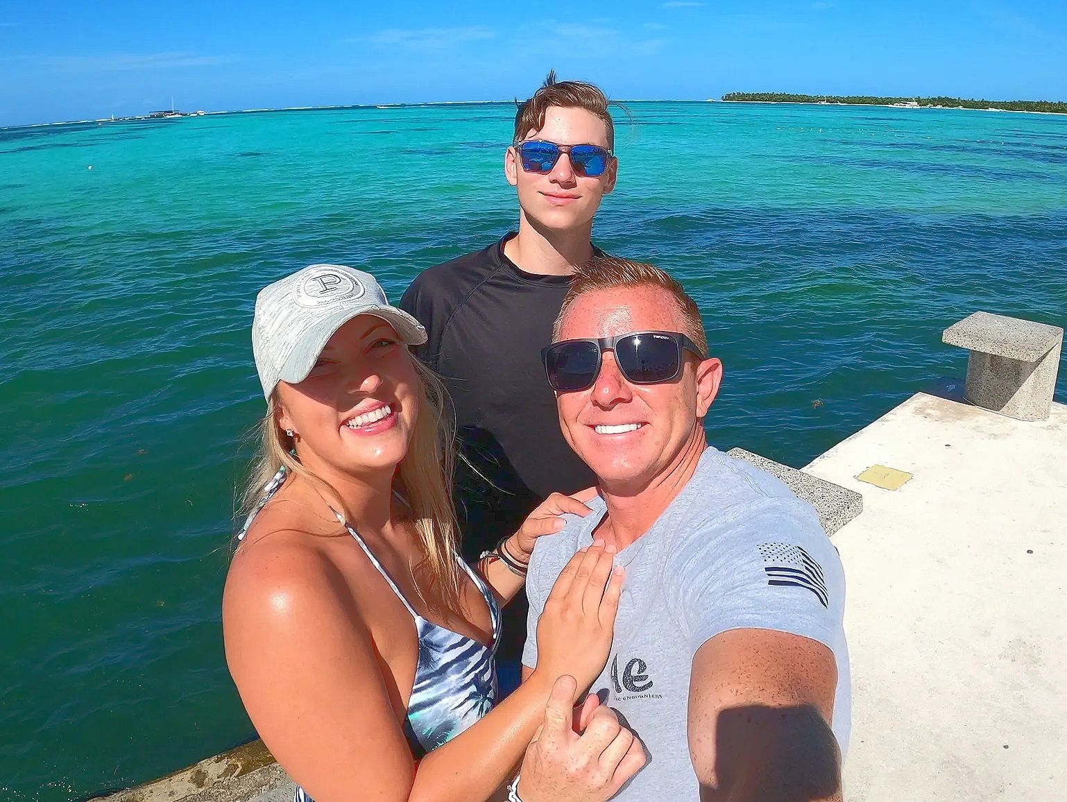 family of three standing in front of the ocean in Punta Cana