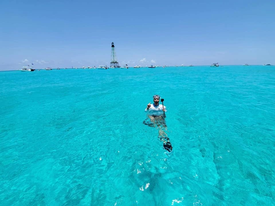 woman swimming in the ocean where you can see to the the ocean floor